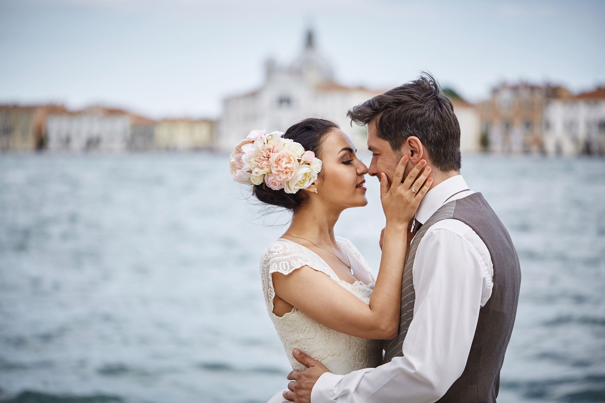 A Venezia, un uomo ed una donna accarezzandosi si sfiorano le labbra. Foto di Mykhailo Shpenyk / DepositPhotos (su licenza).